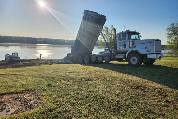 dump truck delivery rock to a lake